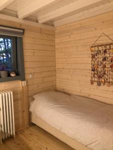a room with a bed in a wooden wall at Vakantiewoning Vrijburg in Schagerbrug