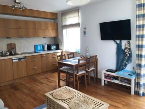 uma cozinha com uma mesa e uma sala de jantar em Apartament Visby em Jurata