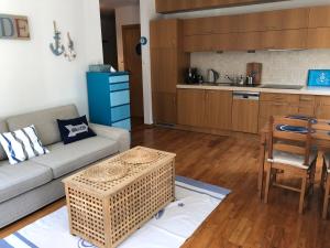 a living room with a couch and a table and a kitchen at Apartament Visby in Jurata