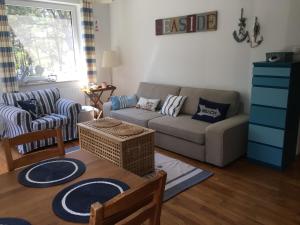 uma sala de estar com um sofá e uma mesa em Apartament Visby em Jurata