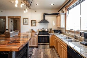 eine Küche mit Holzschränken und einem Herd mit Backofen in der Unterkunft The Adventure Inn Yellowstone in West Yellowstone