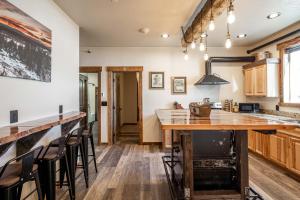 een keuken met een houten aanrecht en barkrukken bij The Adventure Inn Yellowstone in West Yellowstone