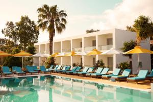 a hotel with a pool with chairs and umbrellas at Nasos Hotel & Resort in Moraitika