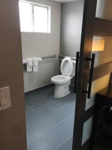 a bathroom with a toilet and a window and towels at The Lexmar - Dodger Stadium Hollywood in Los Angeles