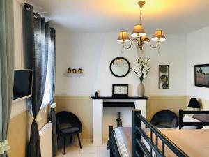 uma sala de estar com uma mesa e cadeiras e uma televisão em La Besace em Sainte-Croix