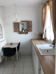 uma cozinha com um lavatório e uma mesa com um espelho em La Besace em Sainte-Croix