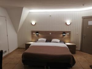 um quarto com uma cama grande e duas luzes na parede em Arconaty Hotel em Linter