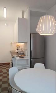 a kitchen with a table and chairs and a refrigerator at Monte Gordo Guest House in Monte Gordo