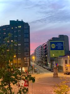 una calle de la ciudad con edificios altos al atardecer en MimApartment In Front Beach Oporto, en Matosinhos