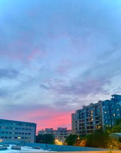 einen Sonnenuntergang in einer Stadt mit hohen Gebäuden in der Unterkunft MimApartment In Front Beach Oporto in Matosinhos + 6 Fotos