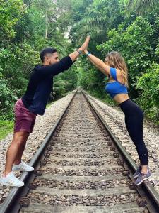 a man and woman holding hands while standing on train tracks at Summit Rainforest Golf Resort & All Inclusive in Paraíso