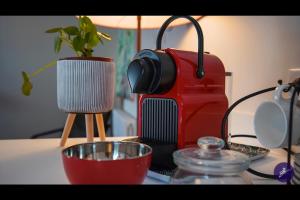 una mesa con una cafetera roja y una planta en Cap Away I Appart Hotel, en Andernos-les-Bains 9 fotos más