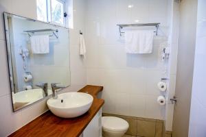 um banheiro branco com uma pia e um vaso sanitário em The Espiritu em Luganville