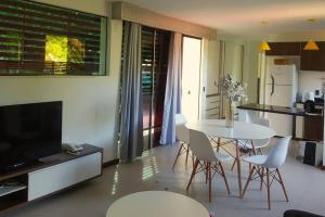 a kitchen and living room with a table and chairs at Casa Pimenta - Apto aconchegante perto da rua do Mucugê in Porto Seguro