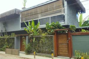 een huis met houten deuren en planten erop bij Casa Pimenta - Apto aconchegante perto da rua do Mucugê in Porto Seguro