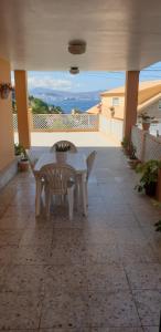 a white table and chairs on a patio with a view at Casa alquiler vacacional 1 in Moaña