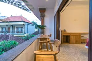 a balcony with a bar with a view of a house at Esty House in Ubud