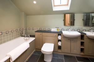 a bathroom with two sinks and a toilet and a bath tub at Time in Galashiels +23 photos