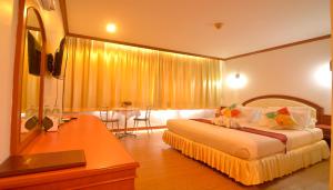 1 dormitorio con 1 cama y vestidor con espejo en Chumphon Gardens Hotel en Chumphon