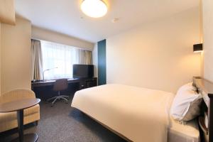 a hotel room with a large bed and a television at Richmond Hotel Yamagata Ekimae in Yamagata