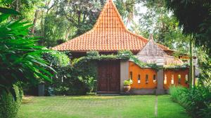 una pequeña casa con techo naranja en un patio en The Studio, en Senggigi 