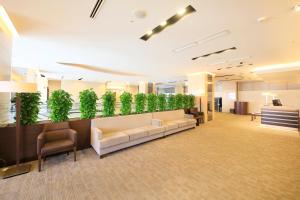 a lobby with a couch and plants on the wall at Richmond Hotel Yamagata Ekimae in Yamagata