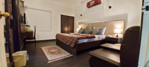 a bedroom with a large bed and a chair at Hilton Bayview lnn in Karachi