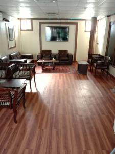 sala de estar con muebles y TV de pantalla plana en Hilton Bayview lnn en Karachi