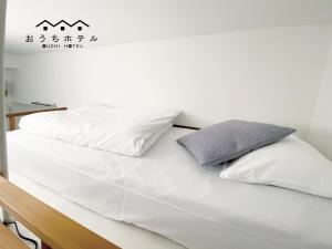 a white bed with white sheets and pillows on it at OUCHI HOTEL Higashi-Hiratsuka #303 in Hiroshima