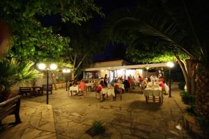 un gruppo di persone sedute al ristorante di notte di Apokryfo, one bedroom apartment close to the beach a Pissouri