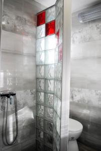 La salle de bains est pourvue de toilettes et d'une cabine de douche en verre. dans l'établissement Hit apartment, à Sevid