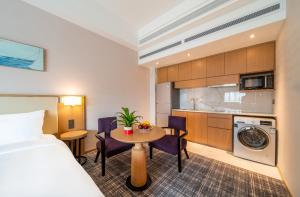 una camera d'albergo con letto, tavolo e cucina di Xence hotel Xiamen a Xiamen