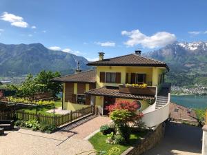 a house with a balcony with mountains in the background at Casa Belvedere in Tenna 