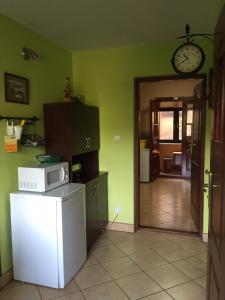 a kitchen with a refrigerator and a clock on the wall at Chata z bali in Sucha Beskidzka