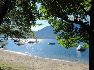 a view of a beach with boats in the water at Villa Art'è in Locarno