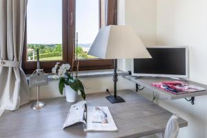 a living room with a table with a lamp and a tv at Alta Villa The Countryhouse Adults Only Boutique BnB in Vigliano d'Asti
