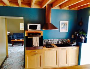 a kitchen with a microwave on top of a stove at L'Etable in Digosville