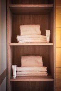 a wooden closet with towels and cups in it at Résidence Les Esplaneilles in Formiguères