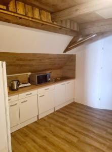 a kitchen with white cabinets and a microwave at Penzion Ostrov u Stribra 13 in Kostelec