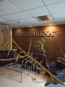 una zona de hotel con sofás de cuero y una pared de ladrillo en Hotel Arena, en Rybnik