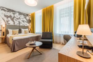 a hotel room with a bed and a chair at Centennial Nexus Hotel Tallinn in Tallinn +37 photos