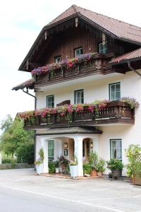 uma casa com caixas de flores na varanda em Hotel garni Weberhäusl em Strobl