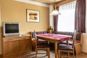 a living room with a table and a television at Gäste- und Appartementhaus Roswitha Huber in Würding