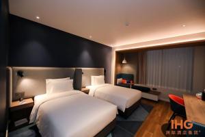 Holiday Inn Express Litang, an IHG Hotel في Lithang: غرفة فندقية بسريرين ومكتب