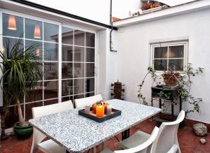 una mesa y sillas en un patio con mesa y ventana en Holiday home La casa azul, en Barcelona