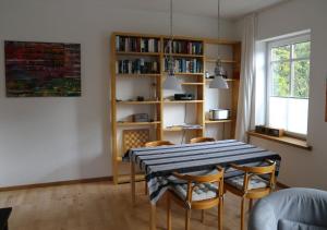 a dining room with a table and chairs and a book shelf at Ferienwohnung Klosterquartier in Lüneburg +15 photos