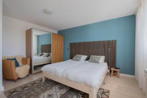 コルトゲーネにあるVakantiehuis aan het Veerse Meerの大きなベッドと鏡のある寝室