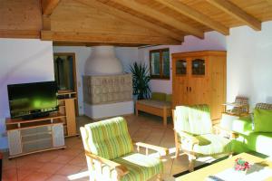 ein Wohnzimmer mit 2 Stühlen und einem TV in der Unterkunft Ferienwohnung Gebirgshäusl in Bischofswiesen
