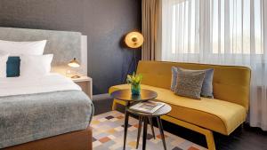 um quarto de hotel com uma cama, um sofá e uma mesa em Hotel Central em Hof