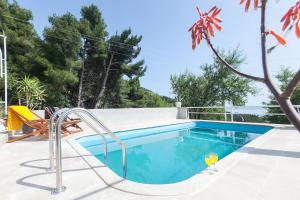 a swimming pool with a glass of wine next to it at Villa Ana in Makarska